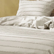 closer view: Close-up of tufted cotton duvet cover and matching pillow showing raised horizontal stripes
